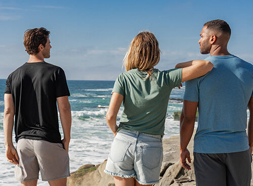 a group of 3 people on a beach wearing bamboo t-shirts