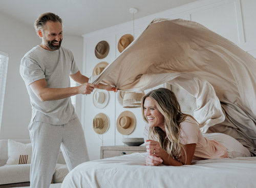a man making a bed with bamboo sheets