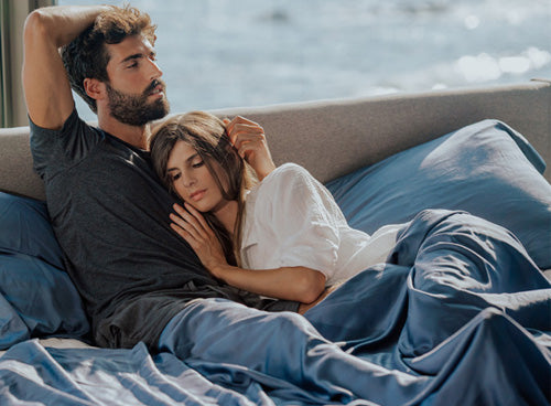 Man and woman lying in a bed with bamboo sheets