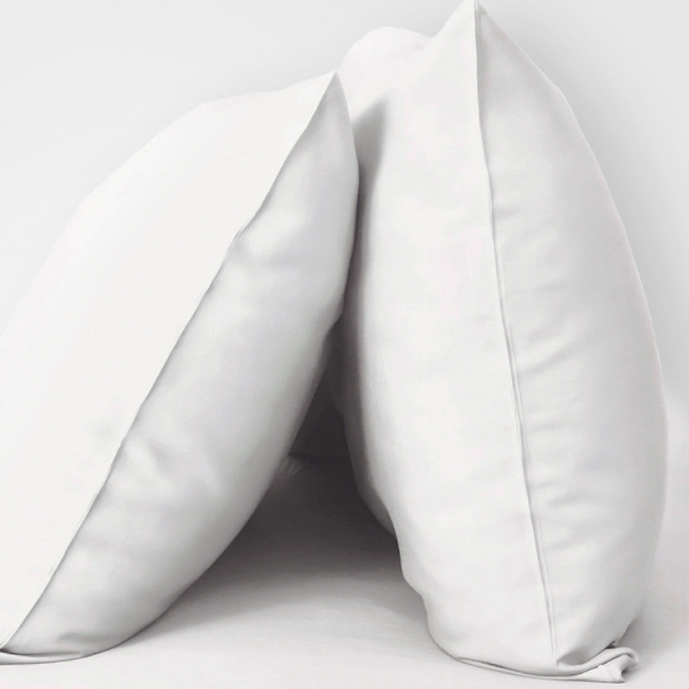 2 pillows with White resort pillowcases on them