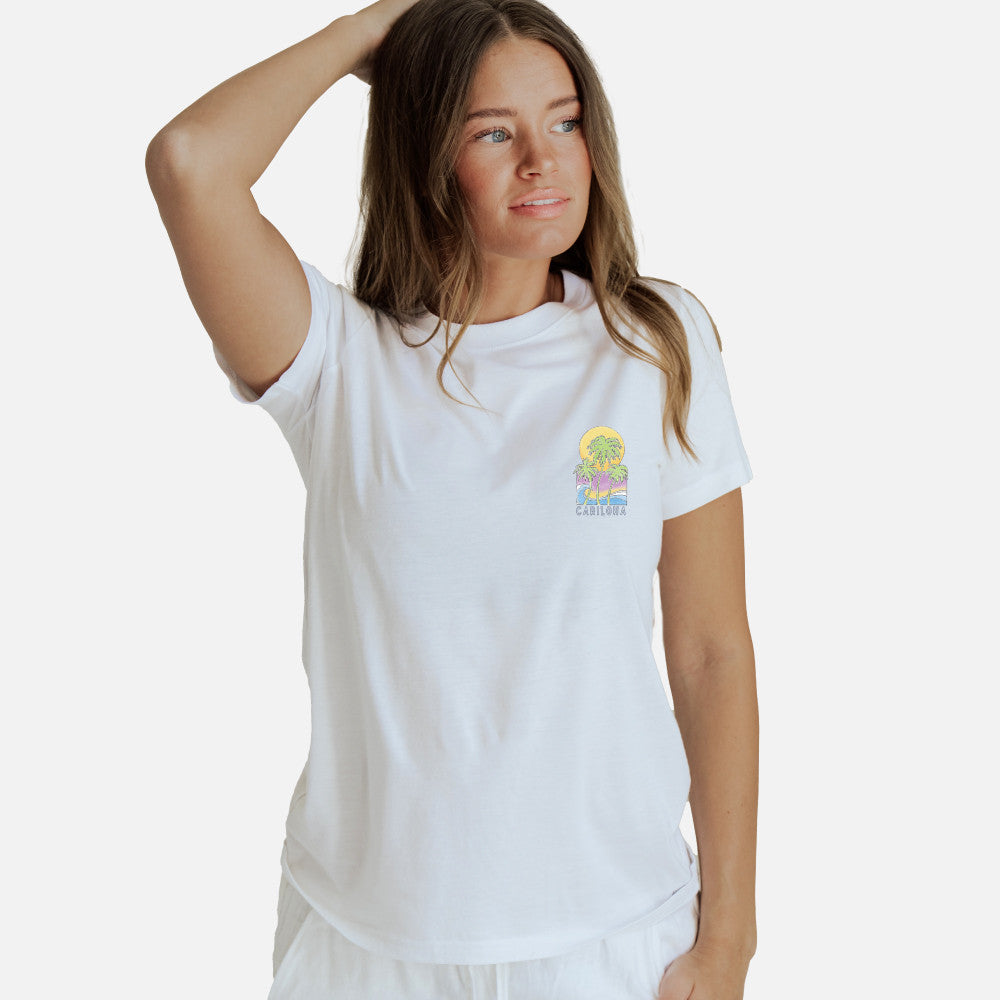 front view of model wearing white crew tee with pastel palms left chest design