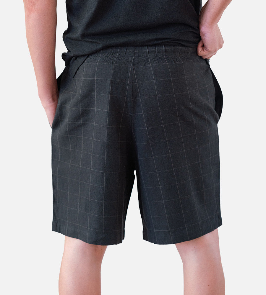close-up back view of model wearing woven black shorts~Plaid Black