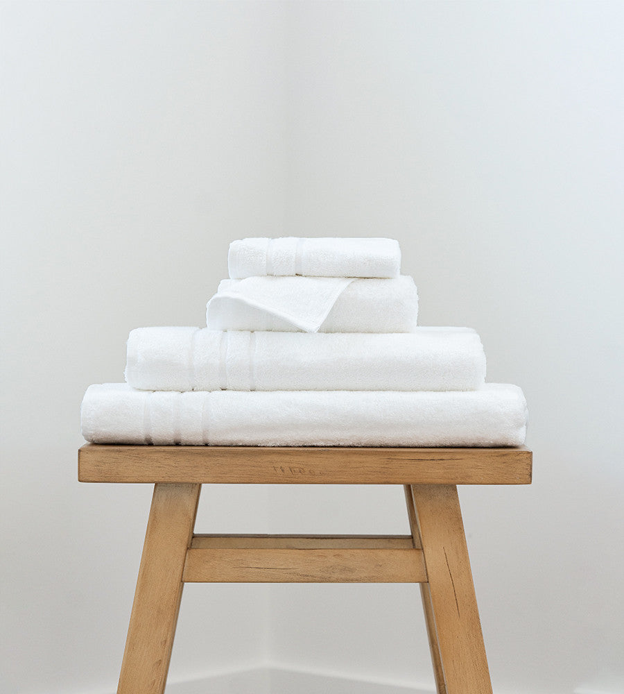 a bath sheet, bath towel, hand towel and washcloth on a stool~White