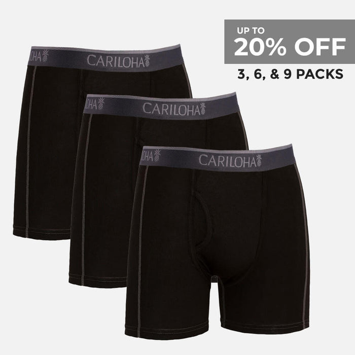Three pairs of black men's boxer briefs with dark gray elastic waistbands featuring the brand name 'CARILOHA' in white, arranged in a staggered stack on a light gray background. A promotional text overlay in the top right corner reads 'UP TO 20% OFF 3, 6, & 9 PACKS'.