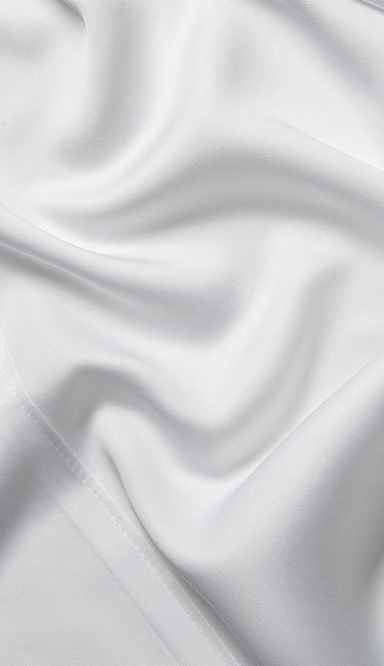 Close-up of a crisp white Cariloha bamboo sheet, softly draped and lit with natural light