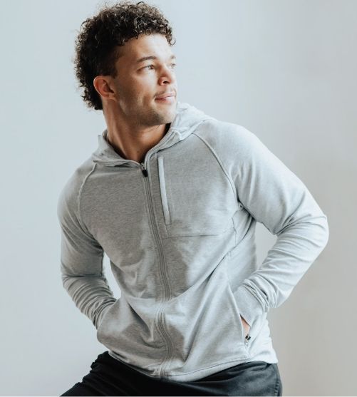 Man wearing a heather grey Cariloha bamboo zip hoodie