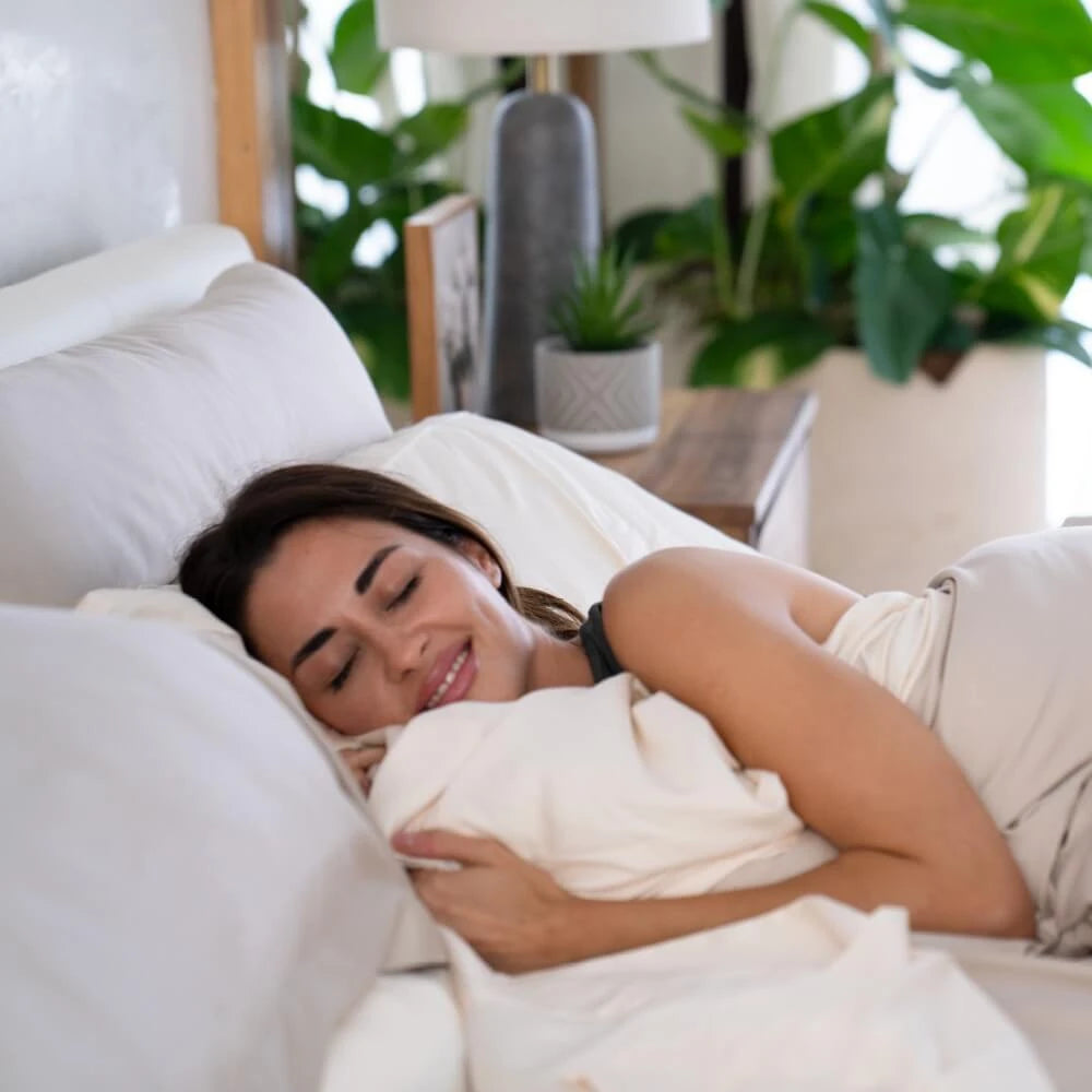 a woman lying in bed with cariloha bamboo bedding