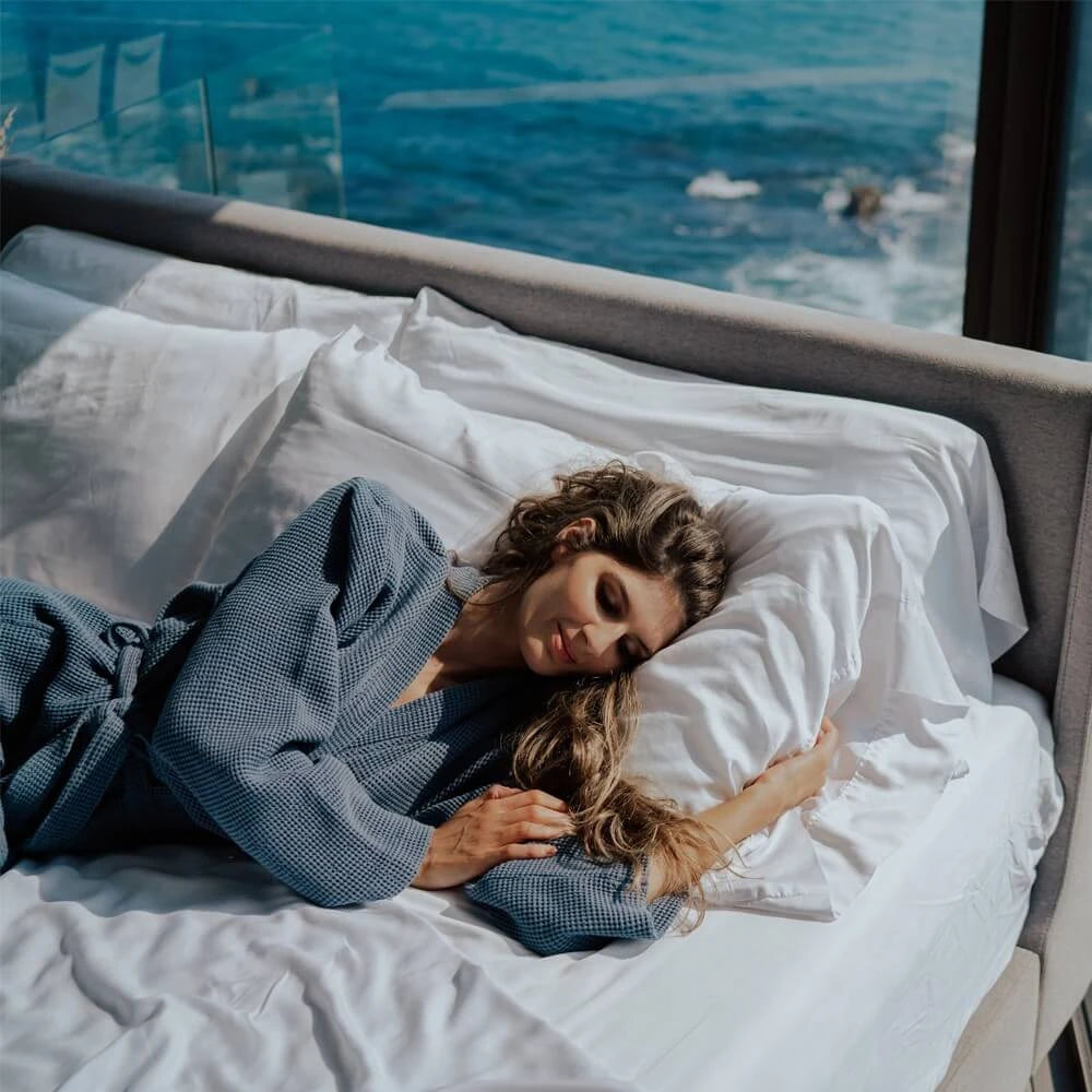 a woman lying on a bed wearing a waffle knit rob
