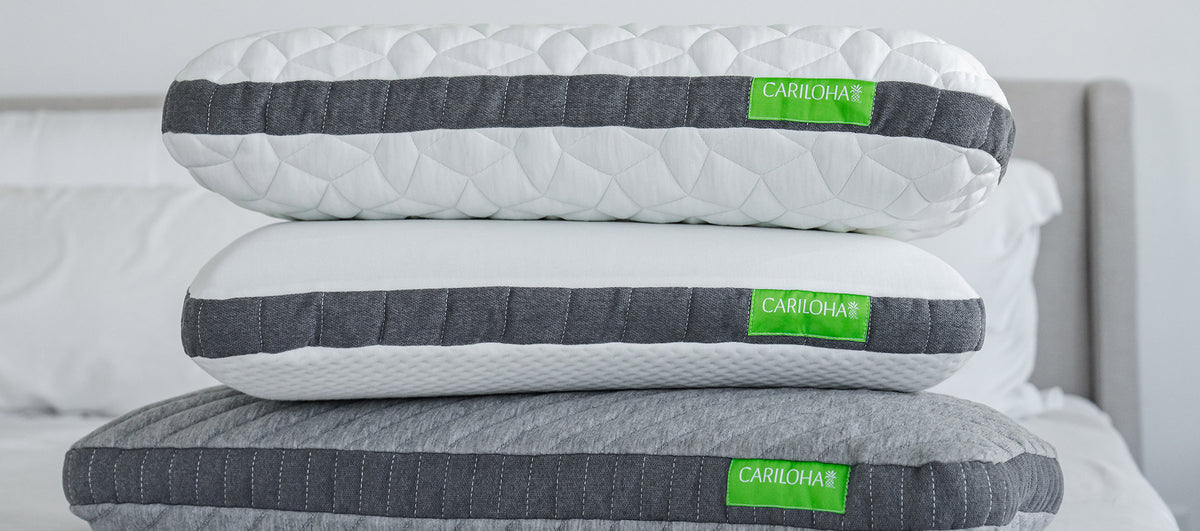 three cariloha pillows stacked on a bed