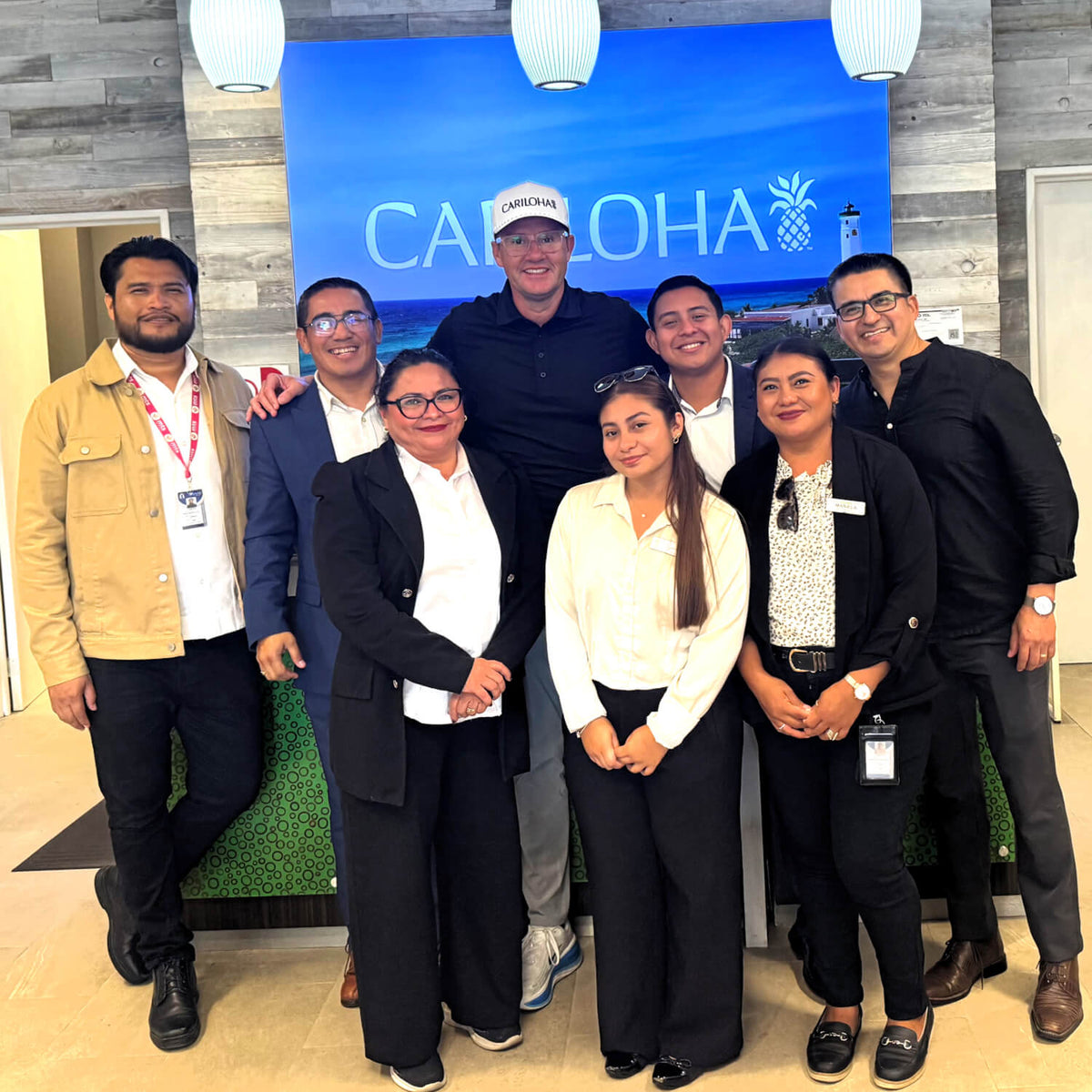 A group of eight people posing together in front of a cariloha sign in a cariloha store in mexico